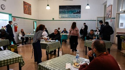 Des personnes démunies mangent un repas à la cantine de la communauté de Sant'Egidio, pendant le confinement dû au Covid, le 13 avril 2020 à Rome (Italie). (VINCENZO PINTO / AFP)