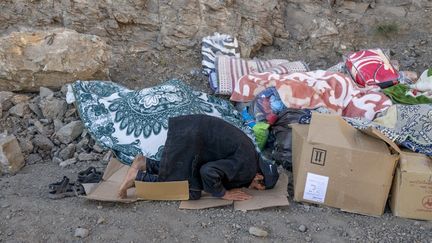 Un homme prie après avoir été sauvé du séisme, dans la zone montagneuse de Tizi N'Test (Maroc), le 11 septembre 2023. (BULENT KILIC / AFP)