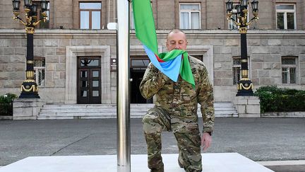 Le président azerbaïdjanais, Ilham Aliev, embrasse un drapeau de son pays avant de le hisser à Stepanakert, la capitale du Haut-Karabakh, le 15 octobre 2023. (SERVICE DE PRESSE DE LA PRESIDENCE AZERBAÏDJANAIS / AFP)