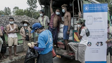Une distribution de denrées alimentaires par le PAM en banlieue de Rangoon (Birmanie), le 21 mai 2021. (STR / AFP)