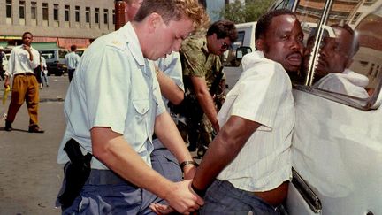 Un policier arrête un suspect à Johannesburg (Afrique du Sud) en 1993. Photo d'illustration (WALTER DHLADHLA / AFP)