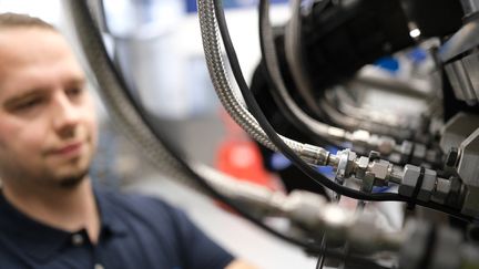 Un employé allemand prépare un moteur dans une usine. Photo d'illustration. (BERND WEISSBROD / DPA / VIA AFP)