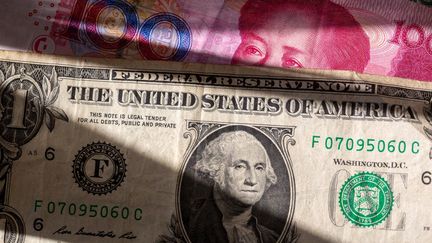 Un billet américain et un billet chinois. (Photo d'illustration). (FERNANDO GUTIERREZ-JUAREZ / DPA / AFP)