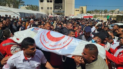 Plusieurs personnes rendent hommage ¨à un des secouristes tués par des tirs israéliens dans la bande de Gaza, à Khan Younès, le 31 mars 2025. (HANI ALSHAER / ANADOLU / AFP)