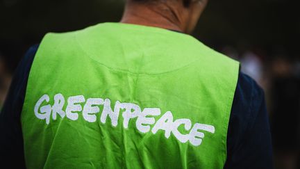 Un militant de Greenpeace lors d'une manifestation, à Paris, le 26 août 2023. (XOSE BOUZAS / HANS LUCAS)