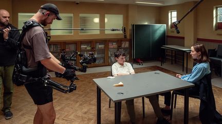 Des techniciens entourent les interprètes de Jamie et de la psychologue sur le tournage de la mini-série "Adolescence", diffusée sur Netflix. (BEN BLACKALL / NETFLIX)