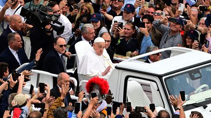 Lors de son dernier bain de foule à bord de la papamobile, le 20 avril 2025 à Rome, le pape François est encadré par deux de ses fidèles lieutenants, l'infirmier Massimiliano Strappetti à sa droite et le prêtre Juan Cruz Villalón à sa gauche. (TIZIANA FABI / AFP)
