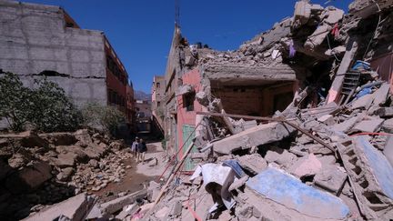 Des habitants passent devant les décombres d'un bâtiment dans la ville centrale d'Amizmiz, au Maroc, frappé par le tremblement de terre, le 11 septembre 2023. (- / AFP)