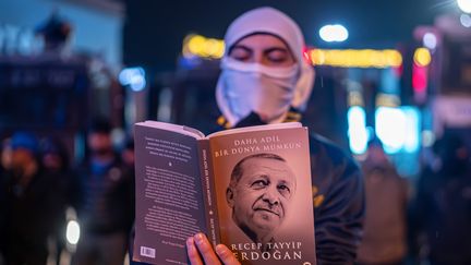 Un manifestant lit le livre du président de Recep Tayyip Erdogan, le 24 mars 2025. (TUNAHAN TURHAN / MAXPPP)